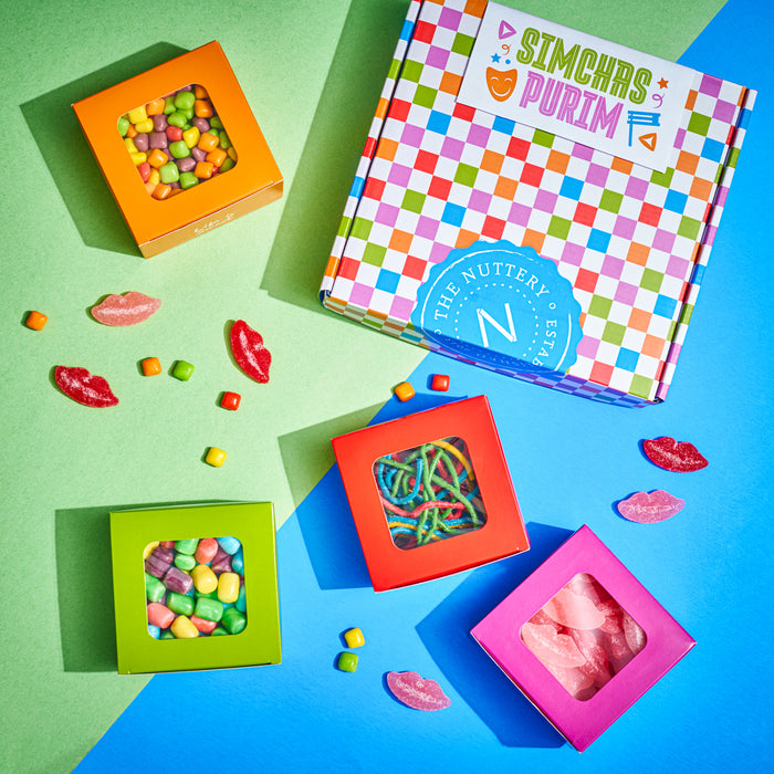 A cheerful candy gift set featuring four colorful boxes of gummies, including rainbow sour belts and fruit chews, arranged beside a checkered "Simchas Purim" gift box. The bright colors and themed packaging make this a fun and festive treat for the holiday.