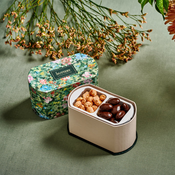 This exquisite gourmet gift box features a floral-printed case filled with premium chocolate-covered nuts and caramelized almonds. A refined choice for weddings, birthdays, and corporate gifting, offering a blend of taste and sophistication.