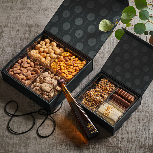 A sophisticated assortment of roasted nuts, sweet treats, and a bottle of indulgent syrup, beautifully packed for any special occasion. This premium gift box is ideal for gourmet food lovers who appreciate high-quality flavors.