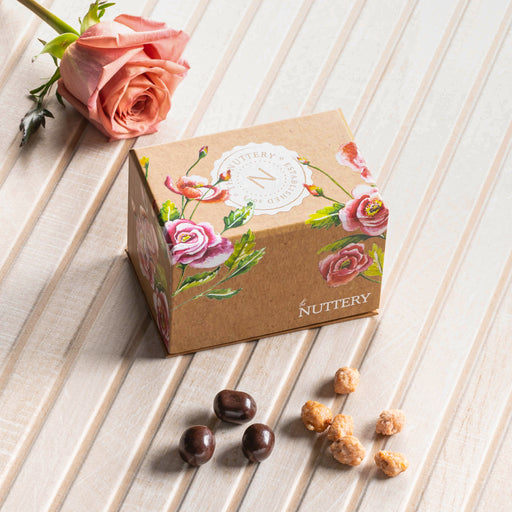 A beautifully crafted floral gift box featuring an exquisite selection of chocolate-dipped almonds and caramelized nuts. The eco-friendly packaging and artistic floral design make it an ideal gourmet present for birthdays, anniversaries, and corporate gifting.