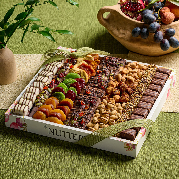 A decadent Tu Bishvat chocolate collection from The Nuttery, featuring handcrafted pomegranate-shaped chocolates and an assortment of dried fruits and nuts.