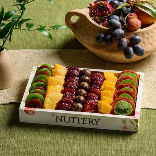 A beautifully arranged dried fruit platter from The Nuttery, featuring a pomegranate-inspired selection of dried fruits, nuts, and chocolate-covered treats.