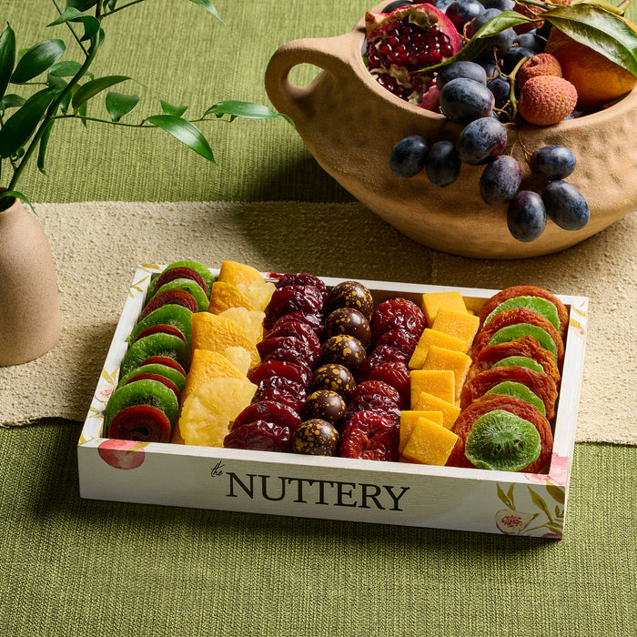 A beautifully arranged dried fruit platter from The Nuttery, featuring a pomegranate-inspired selection of dried fruits, nuts, and chocolate-covered treats.