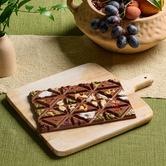 Indulge in a handcrafted chocolate bar topped with a curated selection of dried fruits, nuts, and seeds. The perfect balance of crunch and sweetness, this luxury chocolate treat is a great choice for gift baskets and artisanal chocolate lovers.