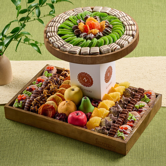 A luxurious two-tiered gift tower from The Nuttery, featuring an array of dried fruits, gourmet chocolates, and premium nuts, arranged in a beautifully crafted wooden tray.