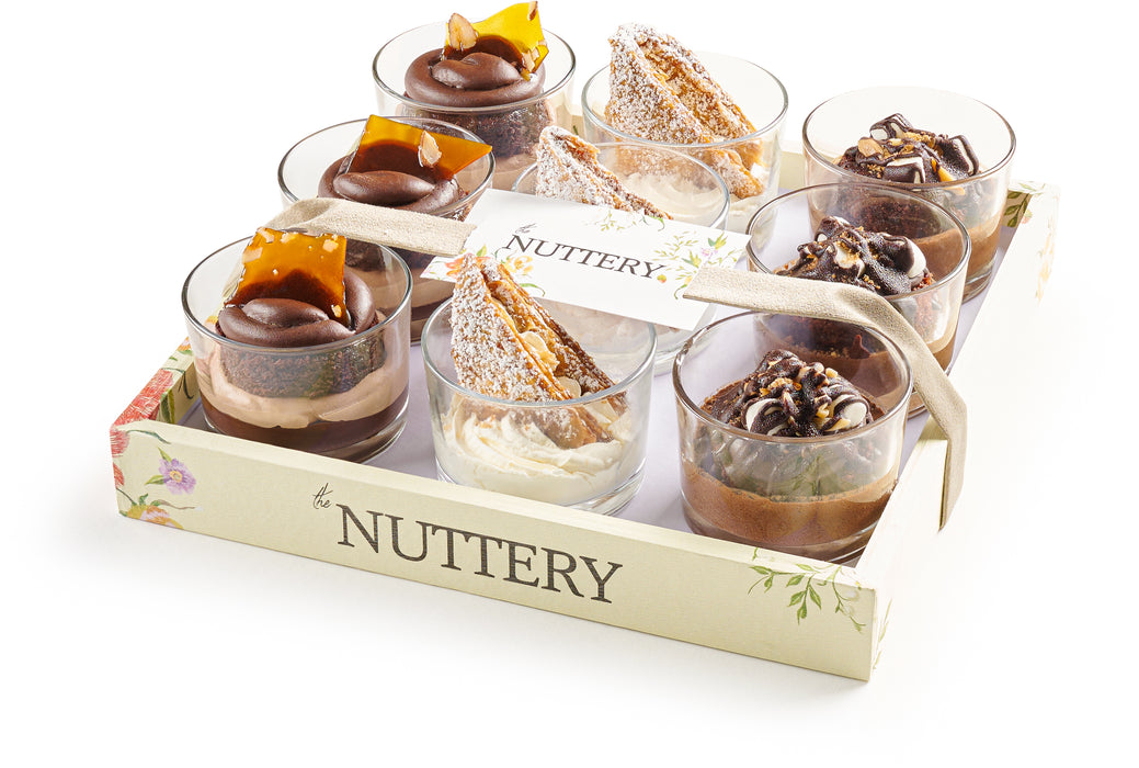 Mousse Cups Assorted- Pareve.webp – A beautifully arranged selection of mousse cups featuring different chocolate and vanilla flavors, elegantly decorated and presented in a floral-themed tray.