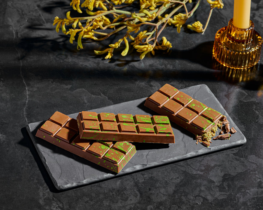 Luxurious Dubai-inspired chocolate bars featuring creamy milk chocolate with vibrant green splashes for a modern, artistic touch. Perfect for gifting or indulging in a unique chocolate experience.