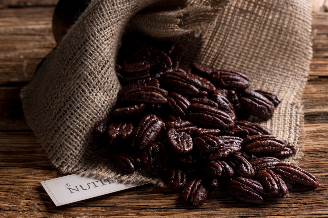 Glossy honey-glazed pecans arranged in a burlap-style bag, perfect for Passover gifting.
