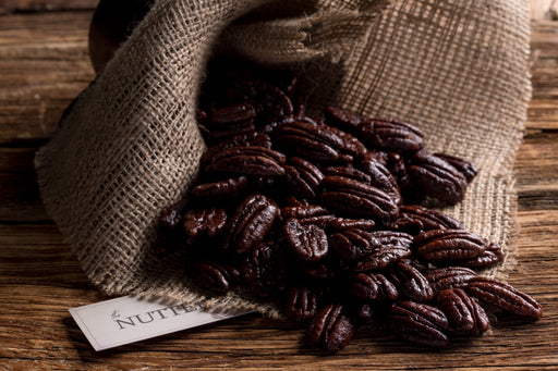 Glossy honey-glazed pecans arranged in a burlap-style bag, perfect for Passover gifting.
