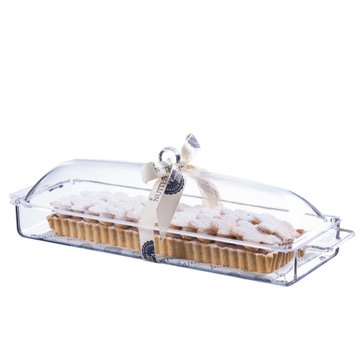 Elegant rectangular tart topped with powdered sugar-coated cookies, displayed in a clear acrylic serving tray and tied with a branded cream ribbon, ideal for festive occasions.