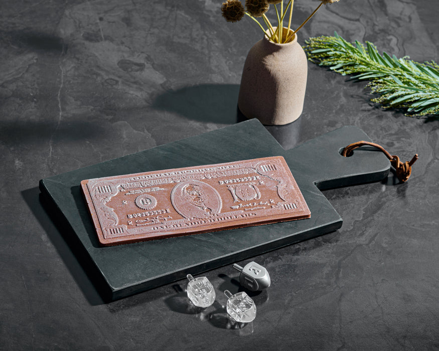Million Dollar Chocolate Bar crafted with high-quality parve chocolate, shaped like a dollar bill, displayed on a black slate board for a luxurious presentation.