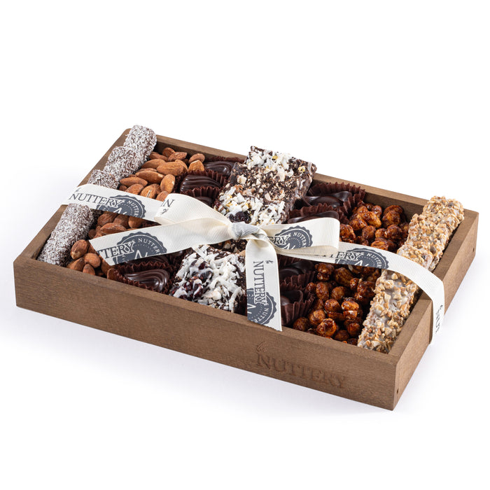 Indulge in an elegant selection of premium chocolates and gourmet nuts with this beautifully arranged gift tray. Packed with a variety of chocolate-dipped treats, crunchy almonds, and delicious nut clusters, this small-sized tray is the perfect way to add a touch of luxury to any celebration. Wrapped in The Nuttery’s signature ribbon, this makes a fantastic gift for holidays, birthdays, or corporate events.