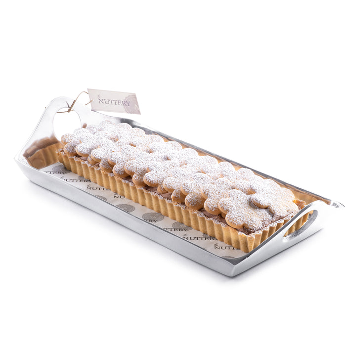 Rectangular tart topped with crispy rolled wafers and whipped cream frosting, elegantly arranged on a ceramic plate for dessert presentations.