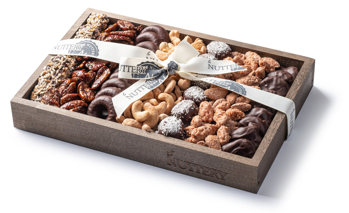 A beautifully arranged wooden gift tray featuring a selection of gourmet nuts, chocolates, and sweets, tied with a satin ribbon. Perfect for Passover celebrations and gifting.