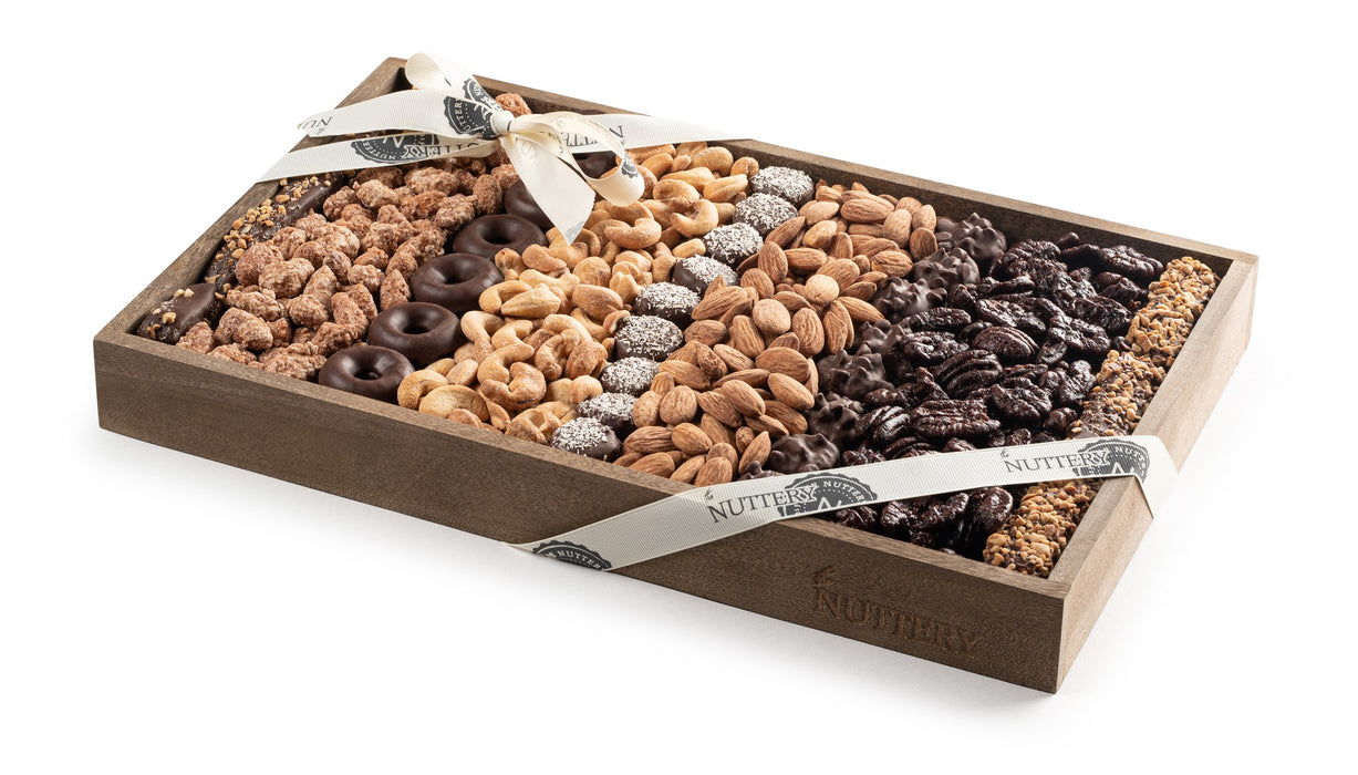 This Kosher for Passover Medium Size Chocolate and Nut Platter features a mix of roasted almonds, cashews, and chocolate-covered nuts, elegantly arranged for any occasion. Wrapped in a signature Nuttery ribbon, it’s a perfect gift for holidays or corporate events.