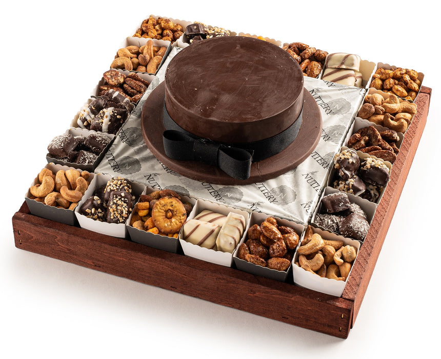 A luxurious wooden tray featuring a chocolate smash hat centerpiece surrounded by assorted nuts, chocolates, and gourmet treats, elegantly arranged for gifting or celebrations