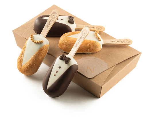 Bride and groom-themed chocolate pops designed as tuxedos and wedding dresses, perfect for elegant celebrations.