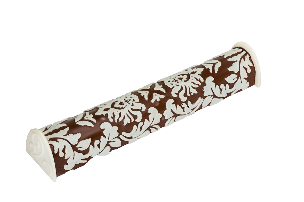 A beautifully crafted chocolate praline log with an intricate floral design in white chocolate. This gourmet dessert is a perfect blend of elegance and rich, creamy flavor.
