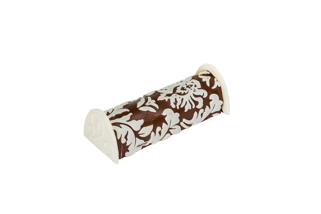 A stunning praline log wrapped in premium chocolate with an intricate white chocolate pattern. This gourmet dessert is a masterpiece of flavor and craftsmanship.