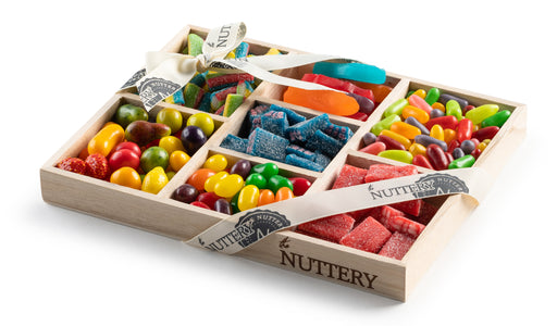 Small wooden gift tray with seven sections of assorted candies, including jelly beans, sour cubes, rainbow bites, and strawberry gummies, elegantly wrapped with a branded ribbon.