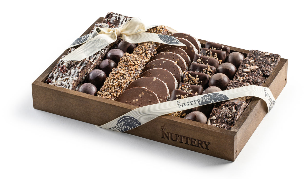 A luxurious chocolate gift tray featuring handcrafted chocolate bars, truffles, and nut-covered treats. Beautifully arranged and ribbon-wrapped, this is an indulgent gift for any celebration.