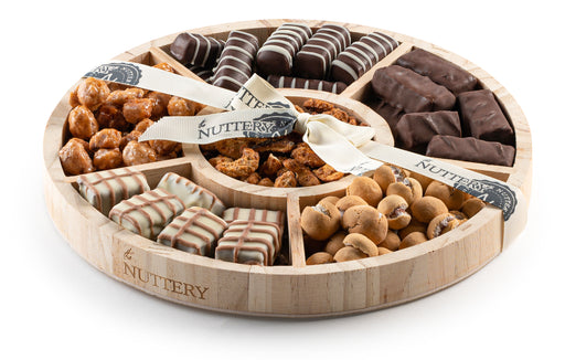 "A compact yet elegant gift tray filled with premium chocolates, roasted nuts, and gourmet confections. Perfect for celebrations, this artisanal assortment is wrapped with a stylish ribbon.