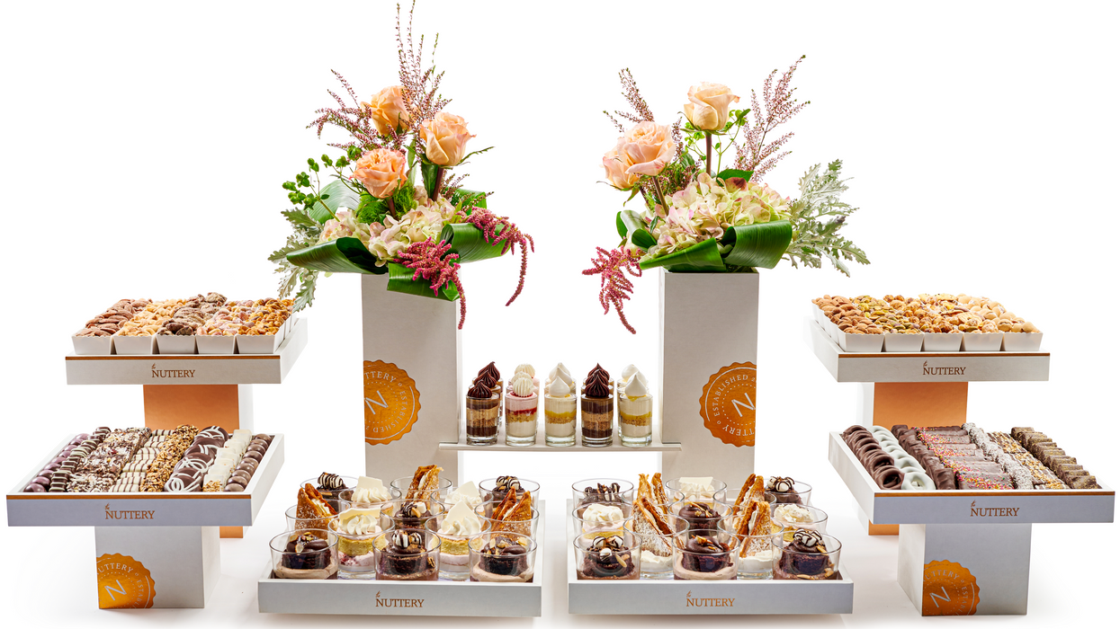 An opulent wedding tower arrangement showcasing artisanal chocolates, gourmet nuts, and luxurious floral décor—perfect for making a grand statement at any event