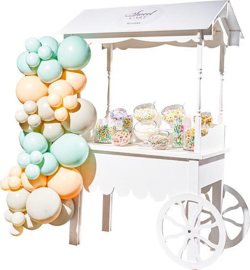 A pink-themed candy cart from The Nuttery, featuring a variety of pink and red sweets, making it a perfect centerpiece for weddings and parties.
