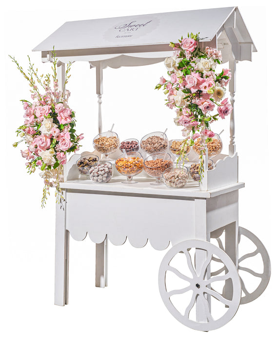 A white vintage-style candy cart loaded with premium nuts, chocolates, and candies, perfect for special occasions and gatherings.