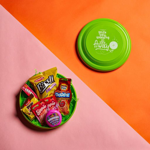 A playful and colorful snack box packed in a custom frisbee lid, featuring a selection of camp-favorite treats and candies. A unique gift for kids, campers, and snack lovers who enjoy fun and flavor in one package.