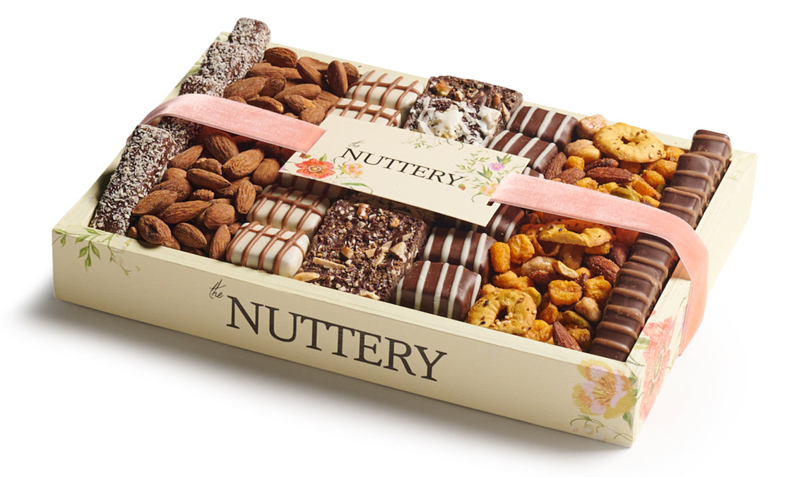 Floral specialty chocolate and nut gift tray from The Nuttery NY, elegantly arranged with gourmet chocolates, roasted nuts, and handcrafted confections, wrapped in a decorative pastel ribbon.