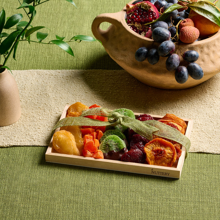 The Nuttery’s elegant small wooden gift tray filled with assorted dried fruits, tied with a green ribbon, perfect for a healthy and delicious gift.