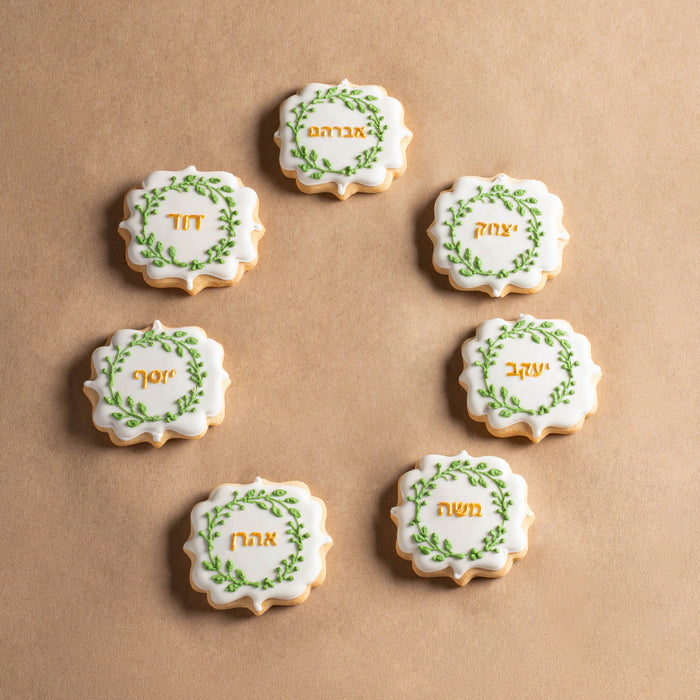 Hand-decorated Ushpizin cookies with intricate green and gold icing for the holiday season. Each cookie is crafted with care, showcasing traditional names in Hebrew lettering for a meaningful presentation.